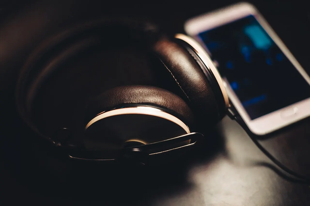 Headphones beside a smartphone used for music listening